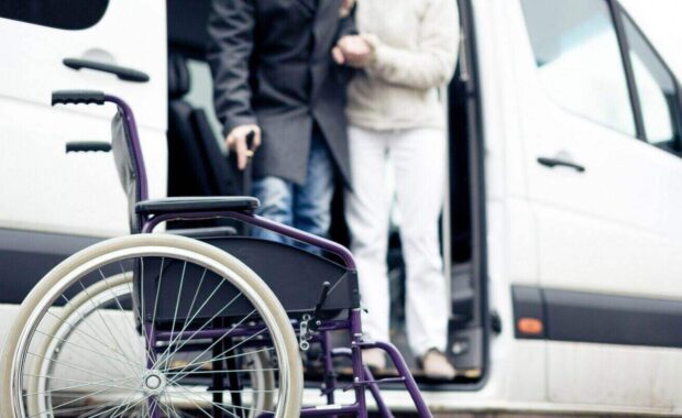 nurse helping senior man exit a van