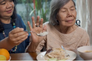 senior asian woman bored with food