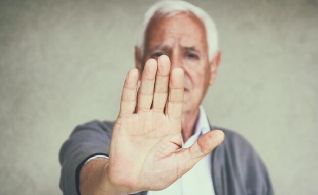 senior man showing his hand as stop sign