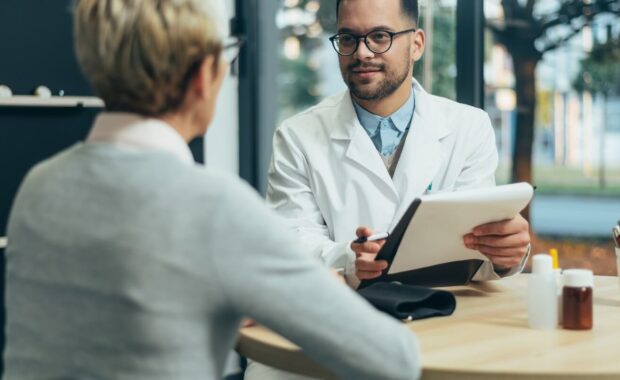 smiling male doctor in consultation with a senior woman patient in a modern office