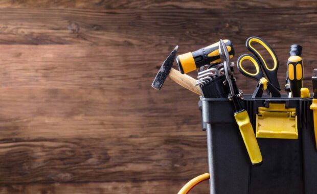plastic black container with many tools on wooden desk