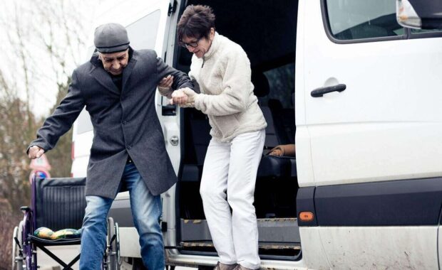 nurse helping senior man exit a van
