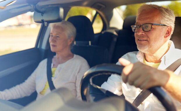 happy senior couple driving in car