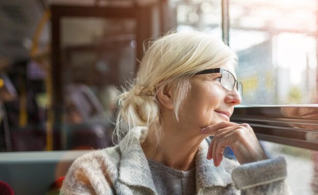senior woman looking through bus window