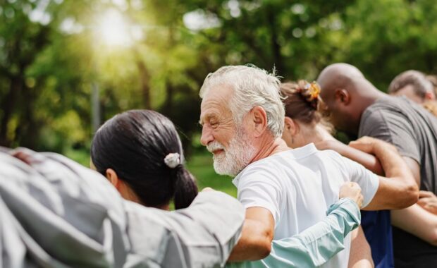 elderly man and diverse people hugging each other - SCNOVA 50+ events