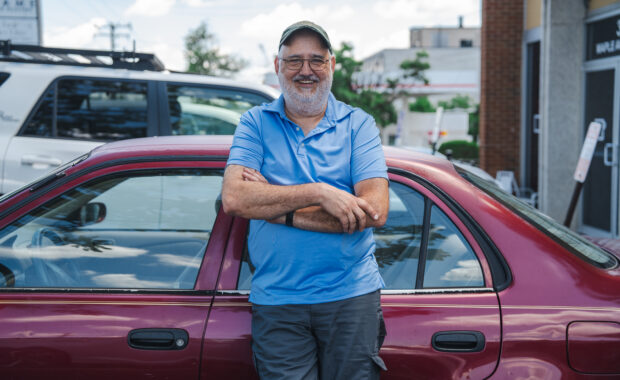 portrait of wolf scherer in front of his car